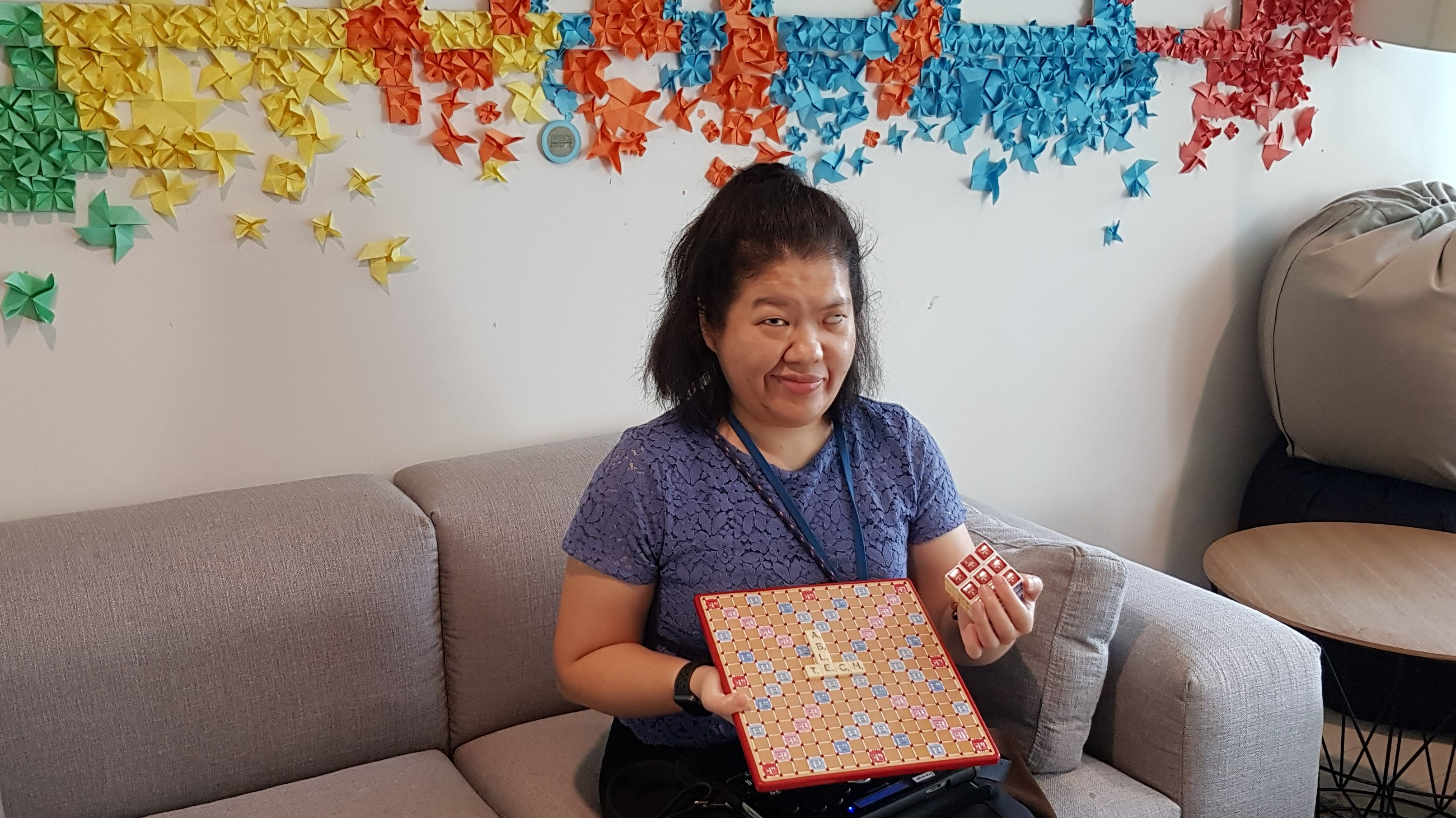 Siew Ling posing with the adapted Scrabble board and puzzle cube