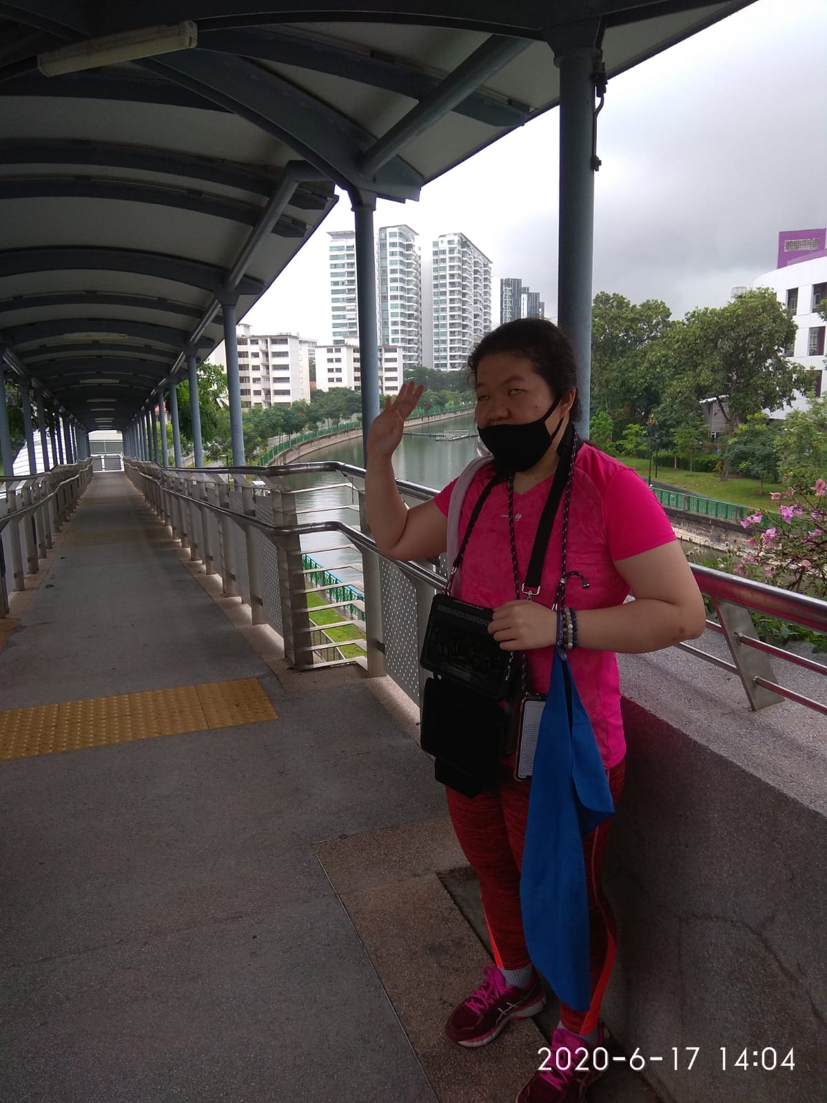 Siew Ling, drenched in the rain, in a sheltered overhead bridge which led to the McDonald's outlet at Stadium with the Goodman Arts Centre behind.