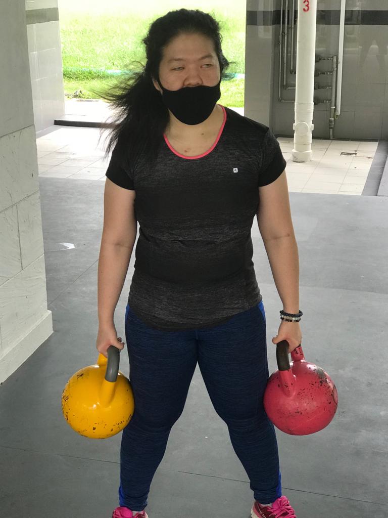 Siew Ling doing her personal training with kettlebells at the void deck, post circuit breaker.