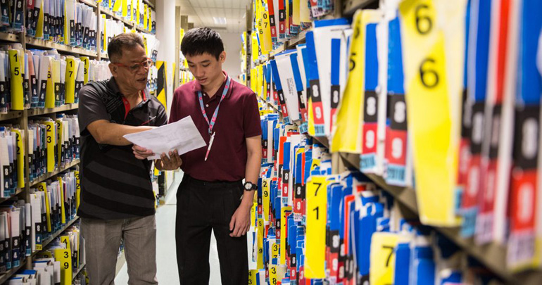 A young man and his supervisor take stock of the day’s work tasks