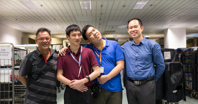 Two employees posing together with their supervisors