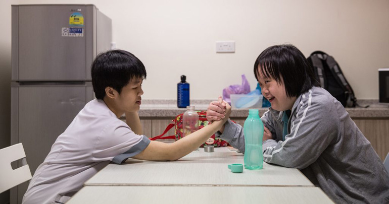 Two internship participants sharing a moment during break time in the NUH pantry room