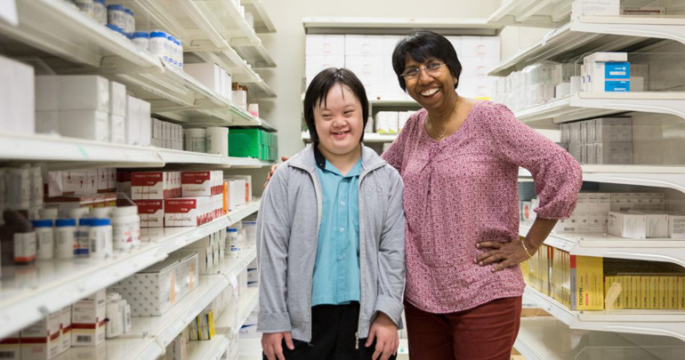 A young employee with her supervisor smiling for a photo at the NUH pharmacy store