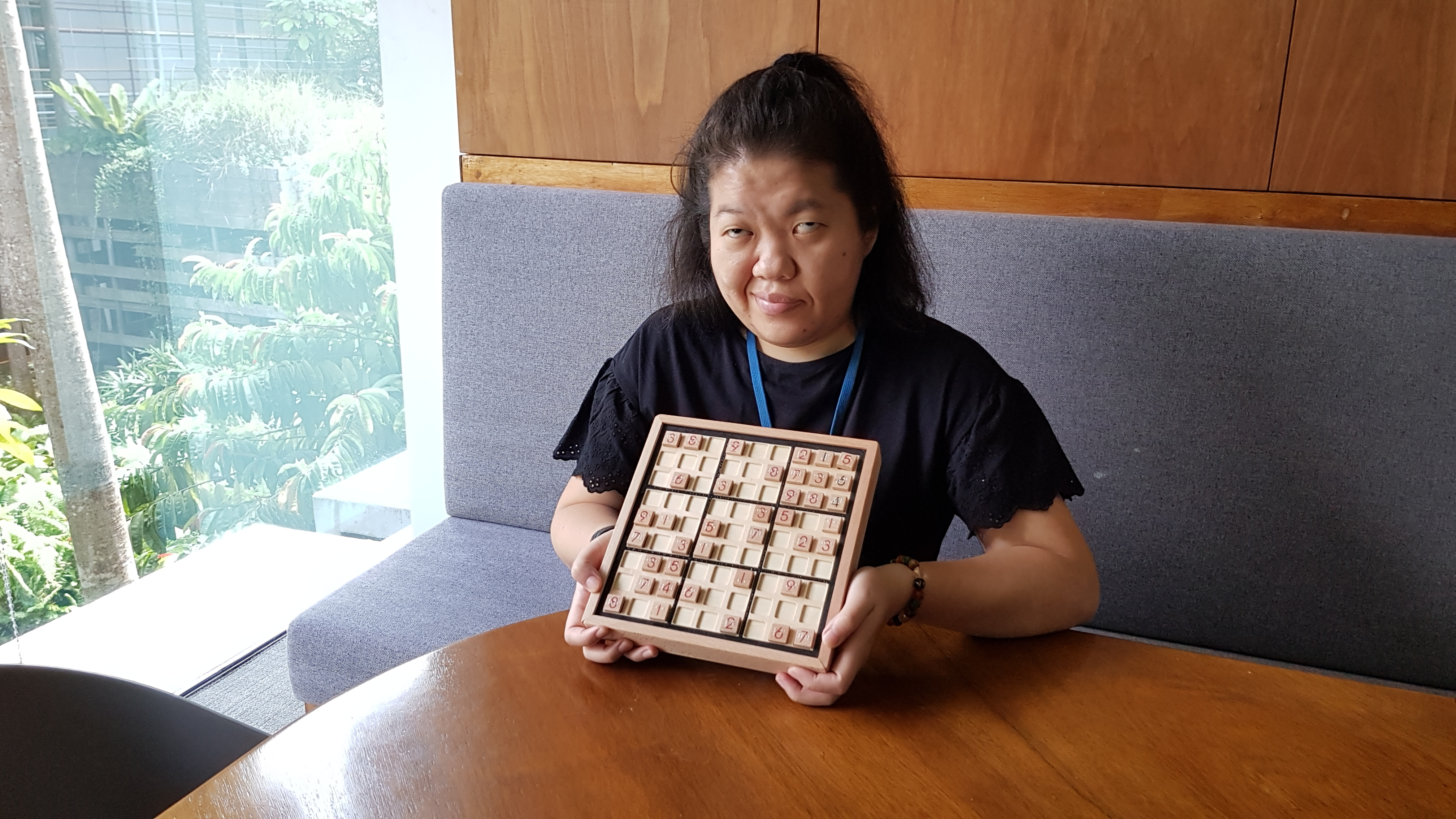 Siew Ling posing with her adapted wooden Sudoku set. 