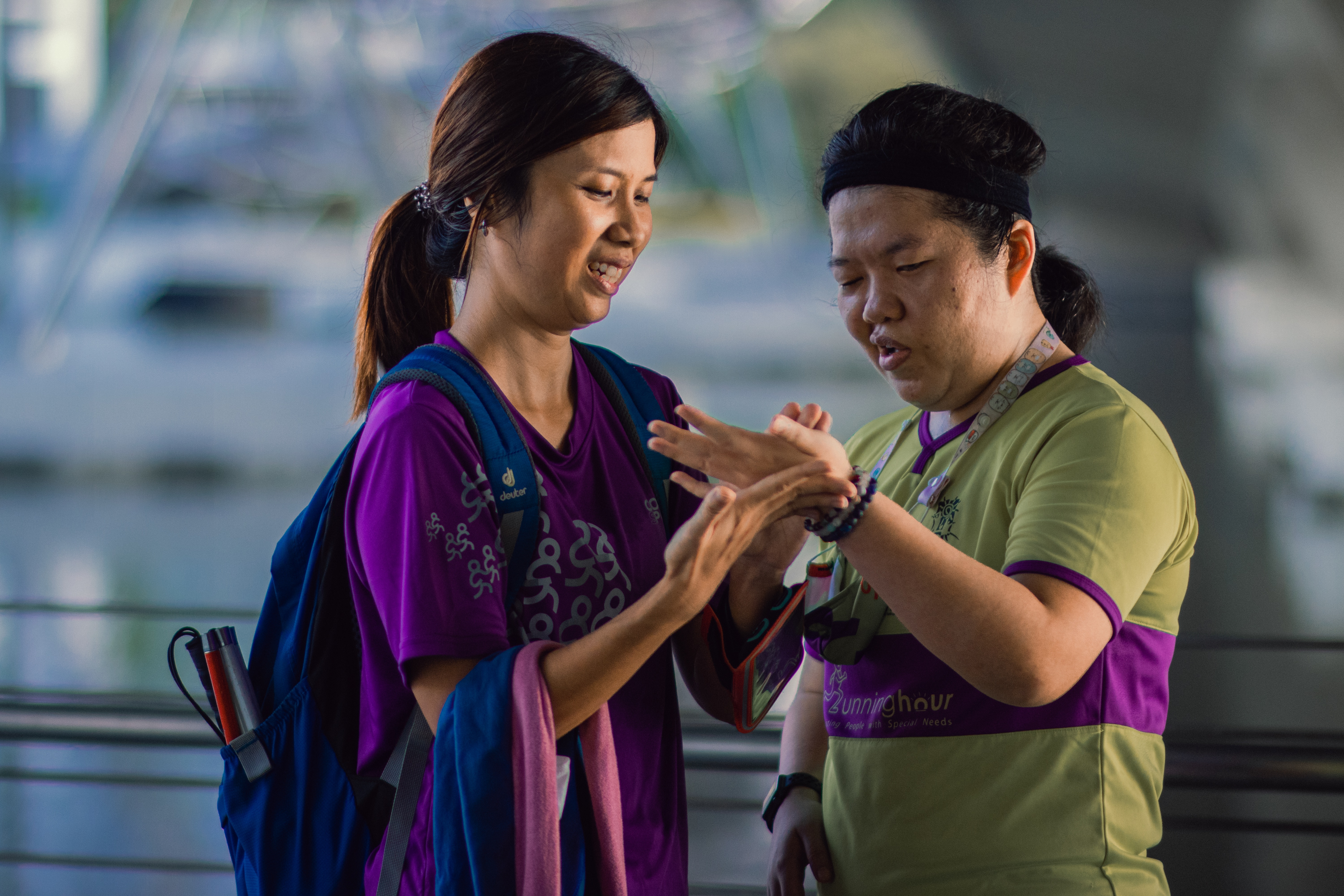 A running guide opening Siew Ling’s palm, and ‘writing’ using her finger.