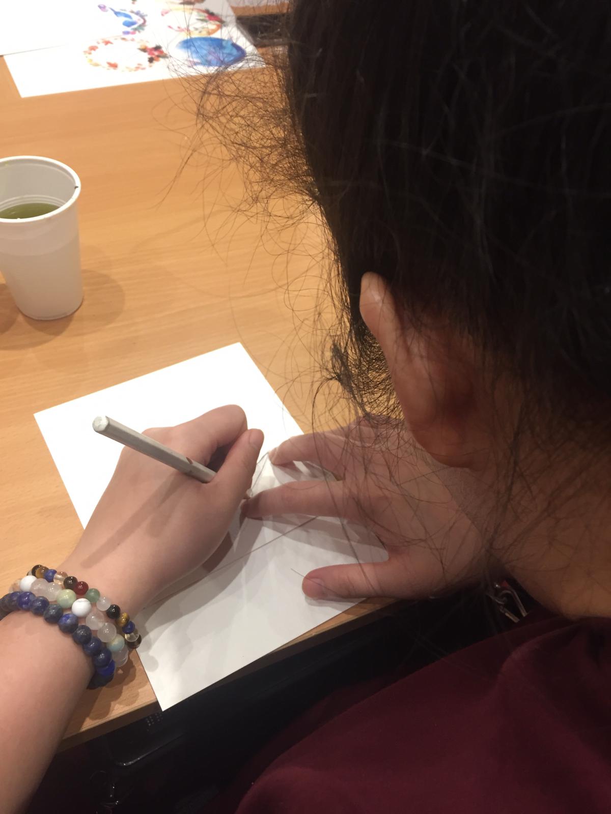 Siew Ling tracing the shape of a bird on a card.