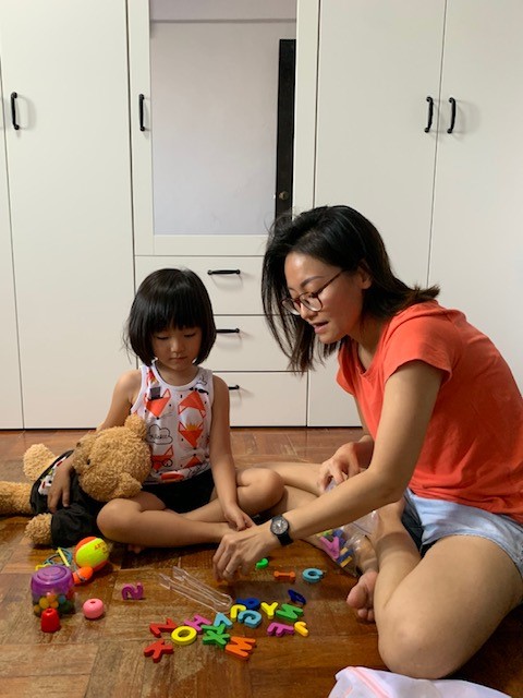 Wen Jing playing with her daughter, who was diagnosed with Global Developmental Delay when she was 20 months old. Wen Jing spending time with her daughter at home, playing with some alphabet blocks.