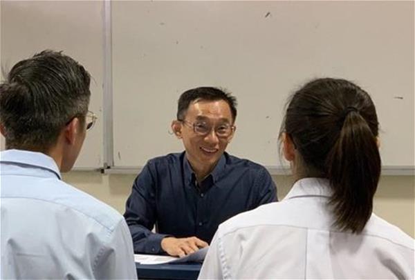 Man talking to two youth.