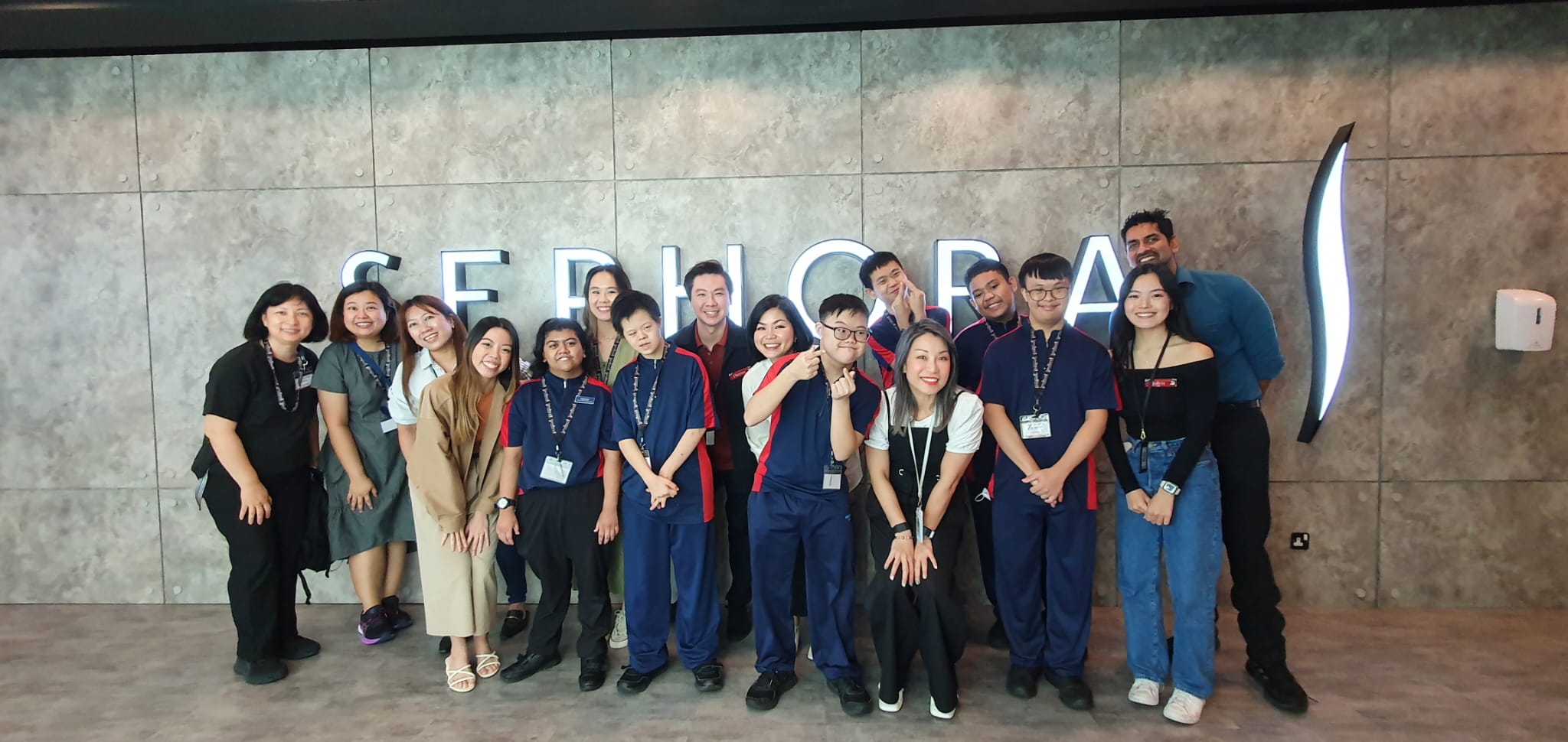 Group of staff and students taking photo at Sephora logo