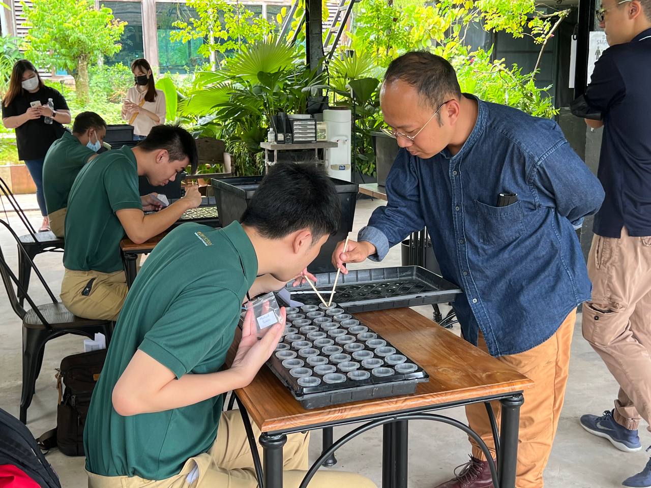 A staff from Tropic Planners guides a student from Eden School in growing seeds.